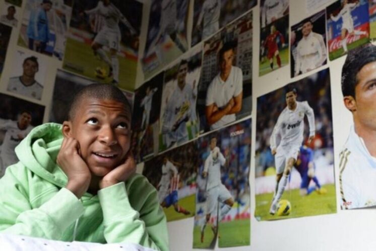 Kylian Mbappé jeune dans une chambre décorée de photos de Cristiano Ronaldo
