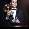 Rodri tenant le Ballon d’Or en costume