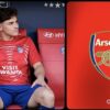 Julian Alvarez assis sur le banc de l’Atlético de Madrid à côté du logo d’Arsenal.